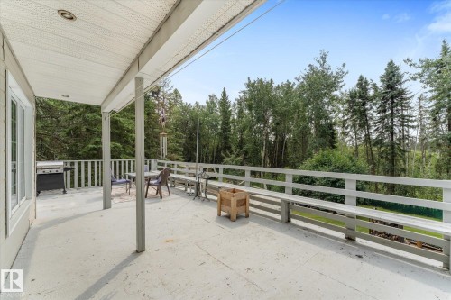 Expansive outdoor deck with a solid railing, offering a private setting surrounded by mature trees - 2, 59031 Range Rd 232, Rural Thorhild County, AB - Outdoor With Deck Patio Veranda