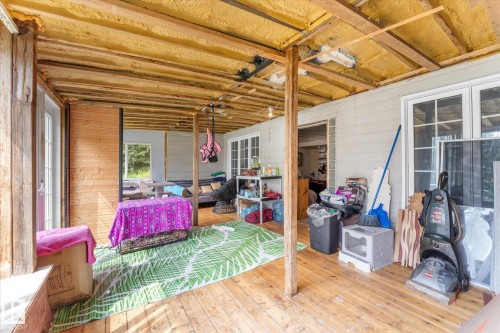 covered in area know as sun room  that leads to the exterior of the lower level - 2, 59031 Range Rd 232, Rural Thorhild County, AB -  With Deck Patio Veranda With Exterior