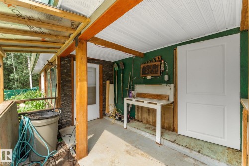 Covered outdoor space featuring exposed wood beams and posts, a white paneled ceiling, and a concrete floor - 2, 59031 Range Rd 232, Rural Thorhild County, AB - 