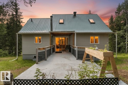 Metal roof with two skylights, siding exterior, expansive concrete patio, and slatted railings - 2, 59031 Range Rd 232, Rural Thorhild County, AB - Outdoor With Deck Patio Veranda With Exterior