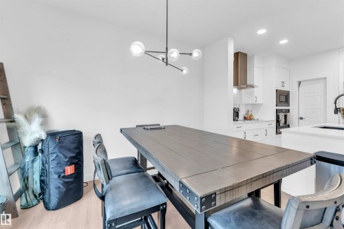 Recessed lighting, wood-finish flooring, white cabinetry, stainless steel range hood, built-in microwave - 3236 Chernowski Way Sw, Edmonton, AB - Indoor