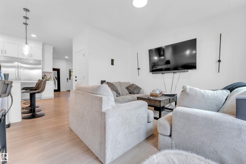 Open-concept living area featuring light wood-finish flooring, white walls, and recessed lighting - 3236 Chernowski Way Sw, Edmonton, AB - Indoor Photo Showing Living Room