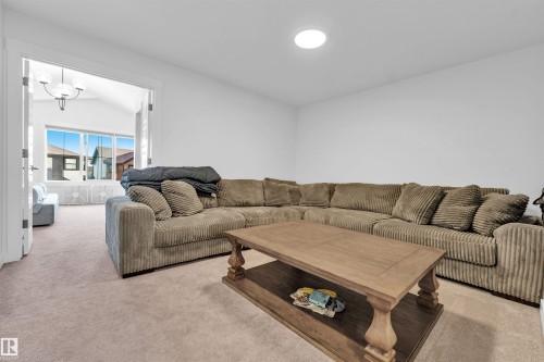 Recessed ceiling lighting illuminates a spacious room featuring wall-to-wall carpeting - 3236 Chernowski Way Sw, Edmonton, AB - Indoor Photo Showing Living Room