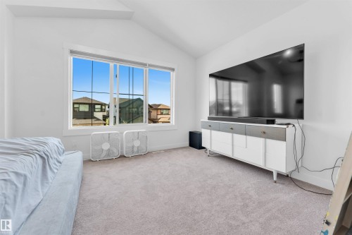 Vaulted ceiling, large window, and carpeted flooring - 3236 Chernowski Way Sw, Edmonton, AB - Indoor
