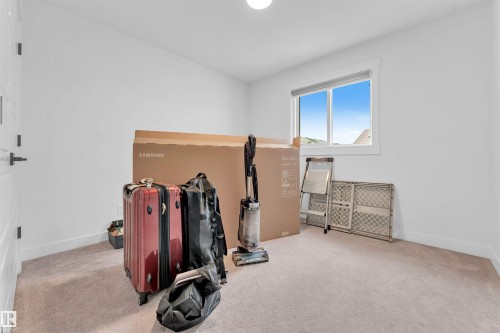 White walls, carpeted flooring, and a single window with a white frame - 3236 Chernowski Way Sw, Edmonton, AB - Indoor Photo Showing Gym Room