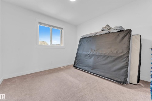 White painted walls, neutral carpet flooring, and a white-trimmed window - 3236 Chernowski Way Sw, Edmonton, AB - Indoor