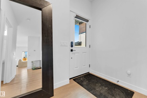 White front door with window inset - 3236 Chernowski Way Sw, Edmonton, AB - Indoor Photo Showing Other Room