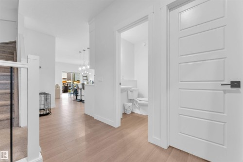 Light wood-finish flooring throughout the main level - 3236 Chernowski Way Sw, Edmonton, AB - Indoor Photo Showing Other Room
