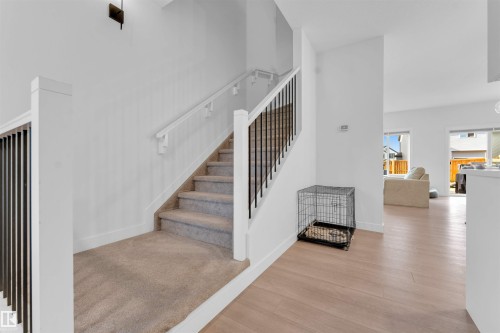 Staircase featuring carpeted treads, white risers, and black vertical balusters - 3236 Chernowski Way Sw, Edmonton, AB - Indoor Photo Showing Other Room