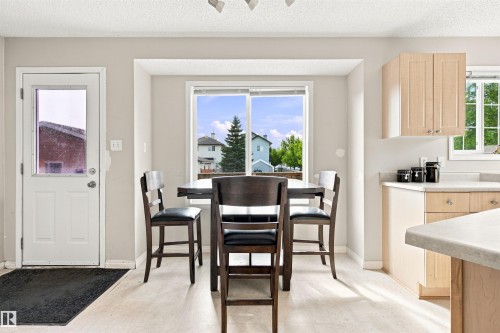 Light-toned wood-finish flooring, white trim, recessed window, and light wood-tone cabinetry - 204 84 Street Sw, Edmonton, AB - Indoor Photo Showing Dining Room