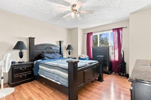 Recessed window with a white frame, overhead ceiling fan, and wood-finish flooring - 204 84 Street Sw, Edmonton, AB - Indoor Photo Showing Bedroom