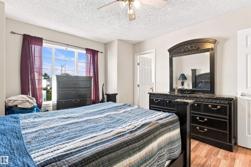 Wood-finish flooring, white paneled door, and a ceiling fan with integrated lighting - 204 84 Street Sw, Edmonton, AB - Indoor Photo Showing Bedroom