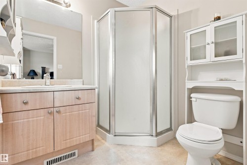 Light wood-finish vanity with countertop, built-in sink, and mirror - 204 84 Street Sw, Edmonton, AB - Indoor Photo Showing Bathroom