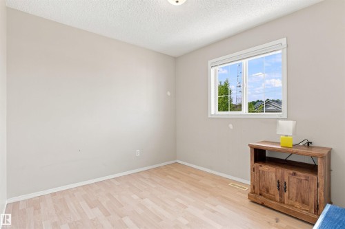 Wood-finish flooring, neutral wall tones, and a window with natural light - 204 84 Street Sw, Edmonton, AB - Indoor Photo Showing Other Room
