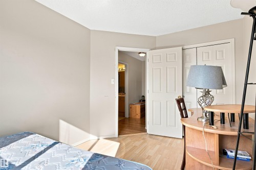 Light-toned wood-finish flooring, white paneled doors, and neutral wall paint - 204 84 Street Sw, Edmonton, AB - Indoor Photo Showing Bedroom