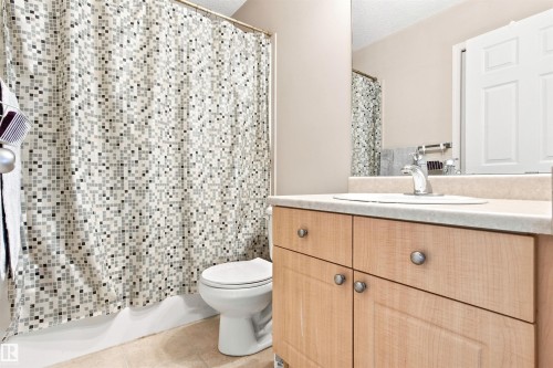 Light wood-finish vanity with a built-in sink, chrome faucet, and integrated mirror - 204 84 Street Sw, Edmonton, AB - Indoor Photo Showing Bathroom