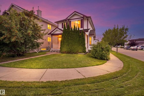 Front exterior featuring a covered porch, gabled roofline, mature shrubs, and concrete walkways - 204 84 Street Sw, Edmonton, AB - Outdoor