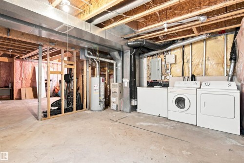 Laundry area featuring a washer and dryer, adjacent to mechanical systems and unfinished space - 204 84 Street Sw, Edmonton, AB - Indoor Photo Showing Laundry Room