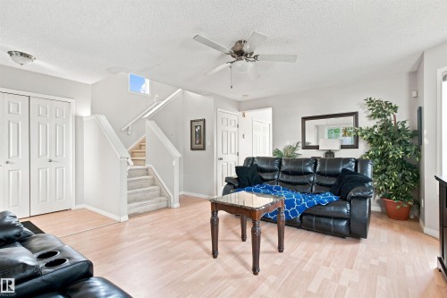 Wood-finish flooring throughout, ceiling fan with integrated lighting, and a skylight providing natural illumination above the staircase - 204 84 Street Sw, Edmonton, AB - Indoor