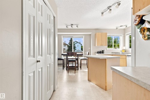 Kitchen featuring light wood cabinetry, light countertops, and track lighting - 204 84 Street Sw, Edmonton, AB - Indoor Photo Showing Kitchen