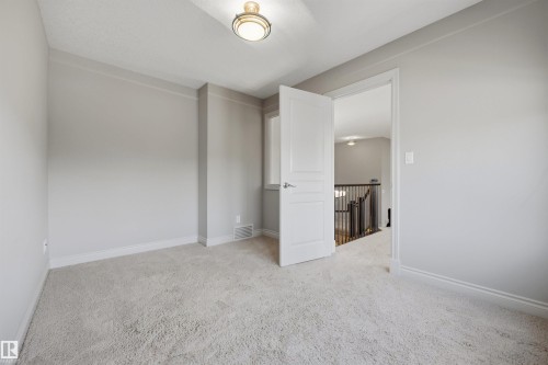 Plush carpeting, neutral wall color, contemporary ceiling fixture, white trim, and a window - 2043 Cameron Ravine Way Nw, Edmonton, AB - Indoor Photo Showing Other Room