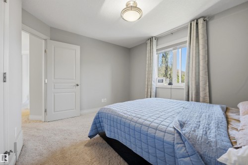 Carpeted flooring, a panel-style door, a single window, and an overhead flush-mount light fixture - 2043 Cameron Ravine Way Nw, Edmonton, AB - Indoor Photo Showing Bedroom
