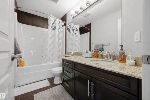 Full vanity with a granite-style countertop and undermount sink - 2043 Cameron Ravine Way Nw, Edmonton, AB - Indoor Photo Showing Bathroom