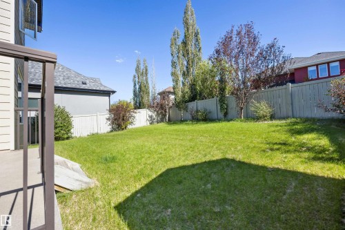 Expansive green space featuring a wood fence, mature trees, and landscaping - 2043 Cameron Ravine Way Nw, Edmonton, AB - Outdoor