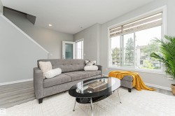 Living area featuring light gray walls, wood-finish flooring, a contemporary window with blinds, and recessed lighting - 