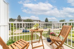 Private balcony featuring white railing, concrete flooring, and a partial privacy wall - 
