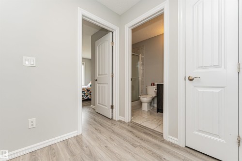 Hallway featuring wood-finish flooring and light gray walls - #61 215 Saddleback Rd Nw, Edmonton, AB - Indoor