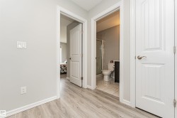 Hallway featuring wood-finish flooring and light gray walls - 