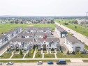 Modern townhome featuring a tri-color facade, private front yard with mature landscaping, and a fenced patio space - #61 215 Saddleback Rd Nw, Edmonton, AB  -  With View 