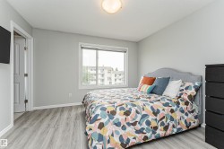 Spacious room featuring light gray walls and wood-finish flooring - 