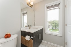 Contemporary bathroom vanity featuring a white countertop, undermount sink, and dark wood-finish cabinetry - 