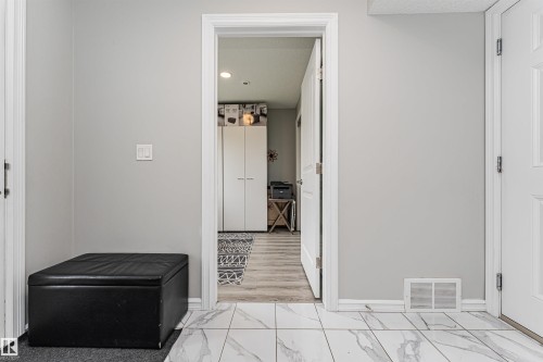 White marble-look floor tiles complement the light gray wall paint - #61 215 Saddleback Rd Nw, Edmonton, AB - Indoor Photo Showing Other Room