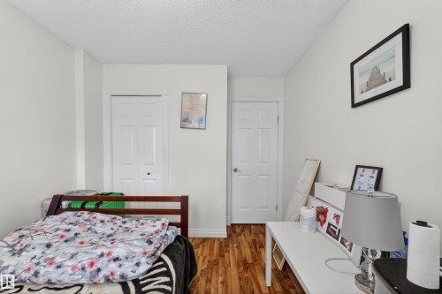 Wood-finish flooring with white baseboards, white walls, and white paneled doors - 9007 169 Avenue Nw, Edmonton, AB - Indoor Photo Showing Bedroom