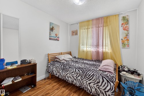 Wood-finish flooring, white walls, and a window with sheer curtains - 9007 169 Avenue Nw, Edmonton, AB - Indoor Photo Showing Bedroom