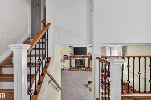 Staircase with wood treads and handrails, complemented by decorative iron balusters - 9007 169 Avenue Nw, Edmonton, AB - Indoor Photo Showing Other Room
