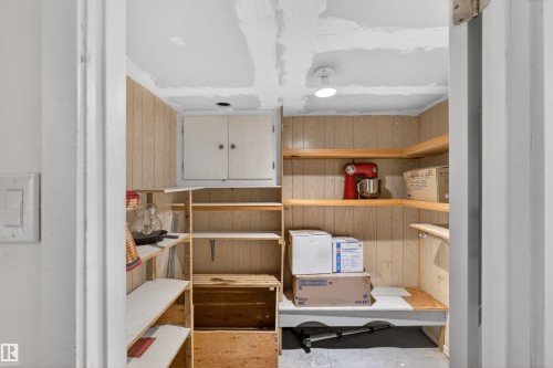 Built-in wood shelving with ample storage capacity, overhead enclosed cabinetry, and recessed ceiling lighting - 9007 169 Avenue Nw, Edmonton, AB - Indoor
