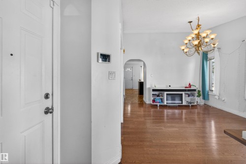Hardwood-style flooring throughout, arched doorway, and built-in lighting fixture - 9007 169 Avenue Nw, Edmonton, AB - Indoor Photo Showing Other Room