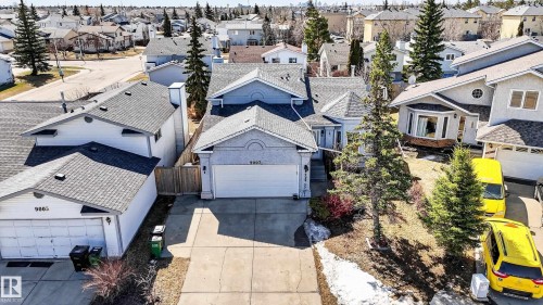 Two-story residence with an attached garage, featuring a bay window, a gabled roofline, and established landscaping - 9007 169 Avenue Nw, Edmonton, AB - Outdoor
