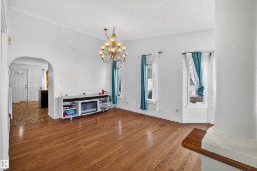 Hardwood flooring, arched doorway, bay window, chandelier - 9007 169 Avenue Nw, Edmonton, AB - Indoor Photo Showing Other Room