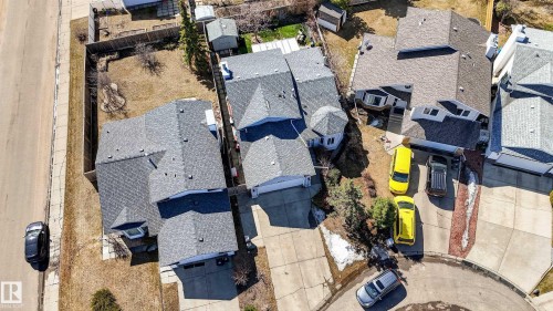 Residential property featuring multiple asphalt shingle rooflines, attached garage, paved driveway, and mature landscaping - 9007 169 Avenue Nw, Edmonton, AB - Outdoor