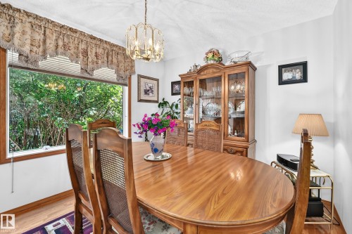 Wood-finish flooring with white walls and a large window - 13069 37 Street Nw, Edmonton, AB - Indoor Photo Showing Dining Room