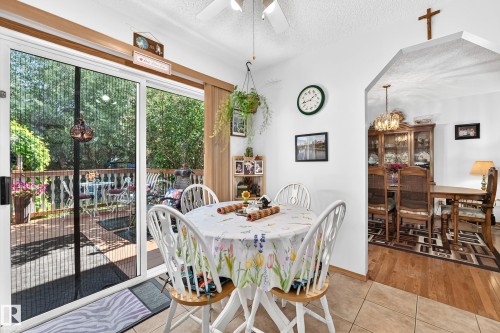 Dining area featuring tile flooring, archway entry, and sliding glass door leading to an outdoor deck - 13069 37 Street Nw, Edmonton, AB - Indoor Photo Showing Dining Room