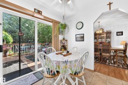 Dining area featuring tile flooring, archway entry, and sliding glass door leading to an outdoor deck - 