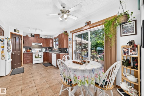 Kitchen with wood-finish cabinetry, tile flooring, and track lighting - 13069 37 Street Nw, Edmonton, AB - Indoor Photo Showing Dining Room