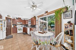 Kitchen with wood-finish cabinetry, tile flooring, and track lighting - 