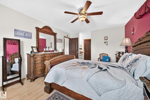 Wood-finish flooring with a ceiling fan light fixture - 13069 37 Street Nw, Edmonton, AB - Indoor Photo Showing Bedroom